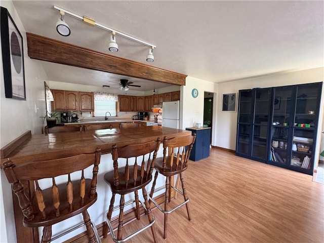 326 Aiken Rd, Shenango Twp Law, PA 16101 - kitchen with a peninsula, freestanding refrigerator, light wood finished floors, brown cabinets, and a ceiling fan