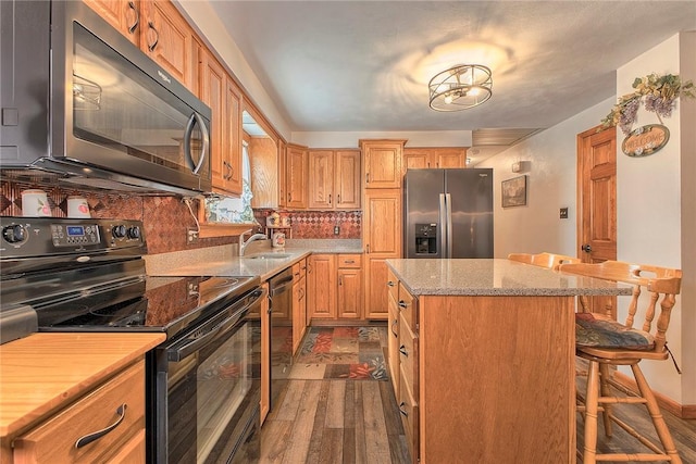 354 Moween Rd, Loyalhanna, PA 15681 - kitchen featuring black range with electric stovetop, stainless steel refrigerator with ice dispenser, dark wood-type flooring, a center island, and dishwashing machine