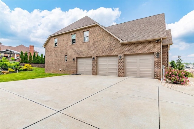 1010 Country Club Rd, Penn Twp Wml, PA 15644 - view of side of property featuring concrete driveway, brick siding, a shingled roof, a garage, and a yard