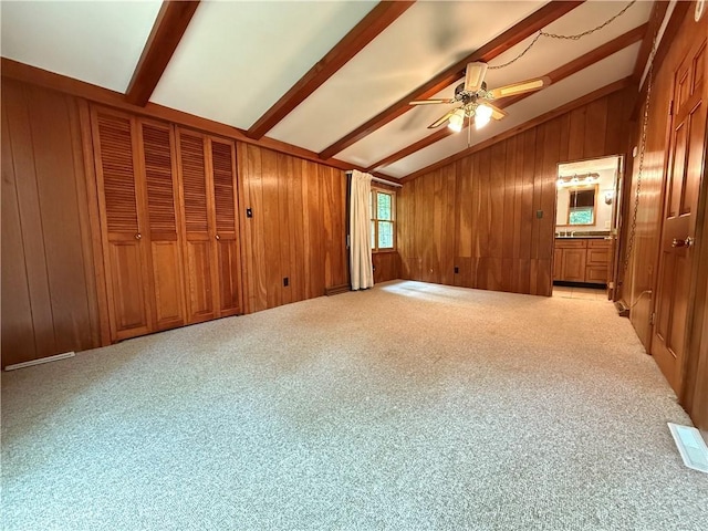 301 Hopper Rd, Delaware Twp, PA 16154 - unfurnished bedroom featuring wood walls, carpet flooring, ensuite bathroom, and a ceiling fan
