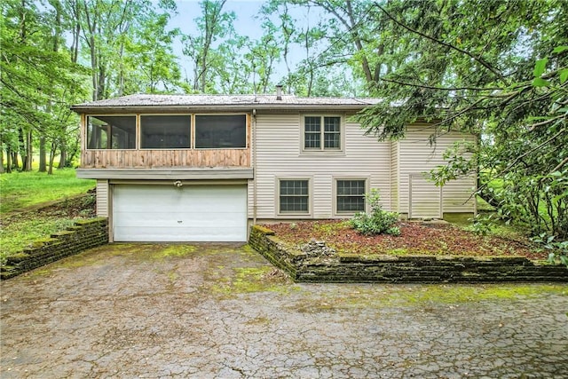 301 Hopper Rd, Delaware Twp, PA 16154 - view of front of house featuring asphalt driveway, a sunroom, a garage, and a metal roof