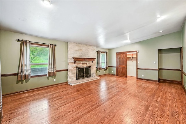301 Hopper Rd, Delaware Twp, PA 16154 - unfurnished living room featuring wood finished floors, a large fireplace, and lofted ceiling