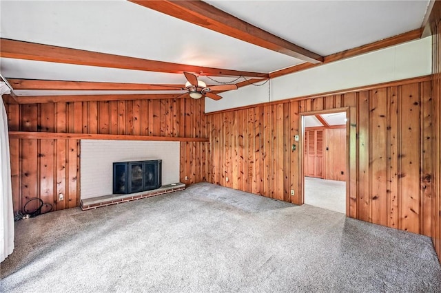 301 Hopper Rd, Delaware Twp, PA 16154 - unfurnished living room with beamed ceiling, a ceiling fan, wood walls, a brick fireplace, and carpet floors