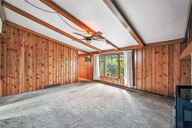 301 Hopper Rd, Delaware Twp, PA 16154 - unfurnished living room with beam ceiling, wood walls, ceiling fan, and carpet floors