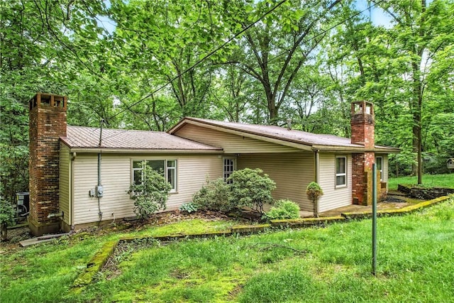 301 Hopper Rd, Delaware Twp, PA 16154 - view of home's exterior with a chimney, a metal roof, and a lawn