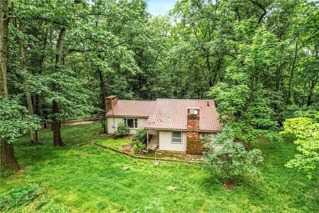 301 Hopper Rd, Delaware Twp, PA 16154 - back of house featuring a chimney, a yard, and a forest view