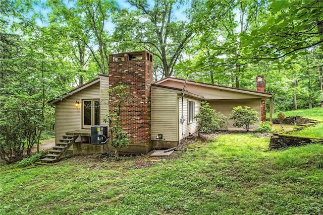 301 Hopper Rd, Delaware Twp, PA 16154 - rear view of property featuring a chimney, a lawn, and stairs