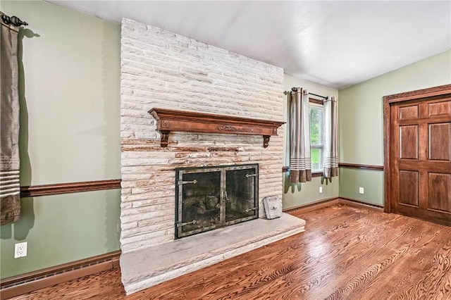 301 Hopper Rd, Delaware Twp, PA 16154 - unfurnished living room featuring baseboard heating, wood finished floors, and a fireplace