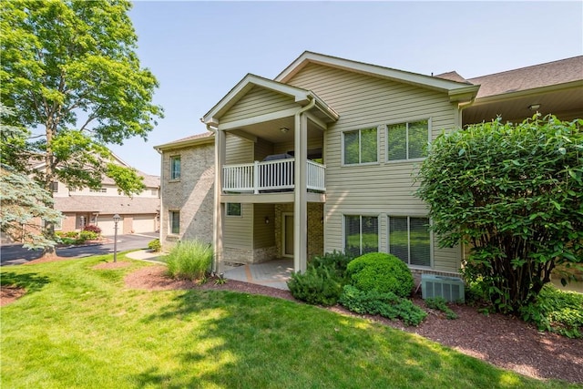 9404 Sundance Dr, South Fayette, PA 15017 - rear view of property featuring a balcony, a yard, and brick siding