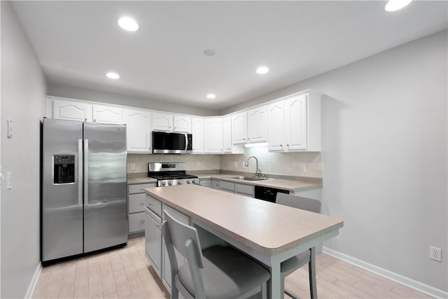 9404 Sundance Dr, South Fayette, PA 15017 - kitchen featuring stainless steel appliances, tasteful backsplash, white cabinets, recessed lighting, and light countertops