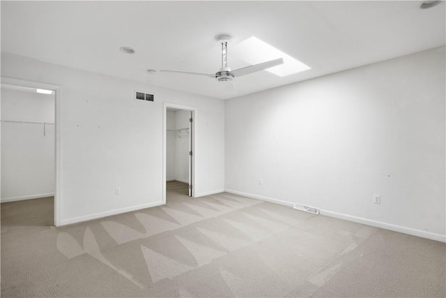 9404 Sundance Dr, South Fayette, PA 15017 - unfurnished bedroom featuring a walk in closet, a skylight, carpet, and ceiling fan