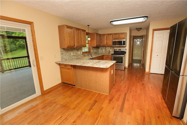 158 Snowdrift Rd, Nottingham, PA 15330 - kitchen featuring appliances with stainless steel finishes, a peninsula, plenty of natural light, brown cabinets, and a textured ceiling