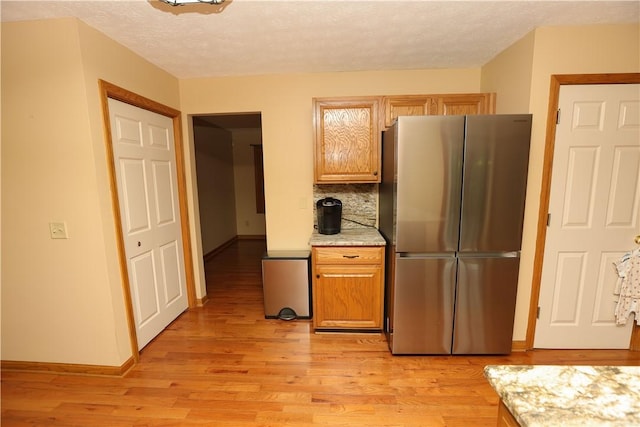 158 Snowdrift Rd, Nottingham, PA 15330 - kitchen with freestanding refrigerator, light wood-type flooring, backsplash, a textured ceiling, and light stone countertops