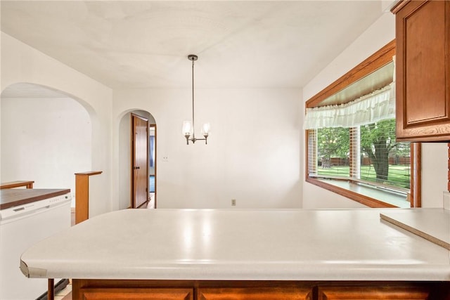 2345 Stoystown Rd, Somerset Twp, PA 15541 - kitchen featuring decorative light fixtures, arched walkways, light countertops, and brown cabinetry