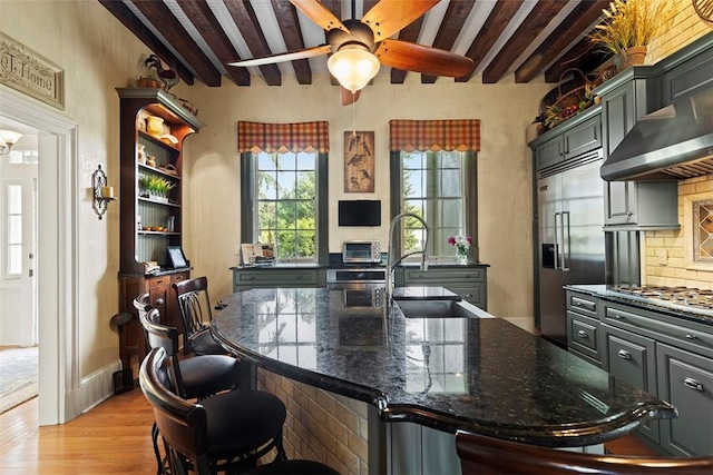 899 Old Thorn Run Rd, Moon/Crescent Twp, PA 15108 - kitchen featuring stainless steel appliances, beamed ceiling, light wood finished floors, wall chimney exhaust hood, and backsplash