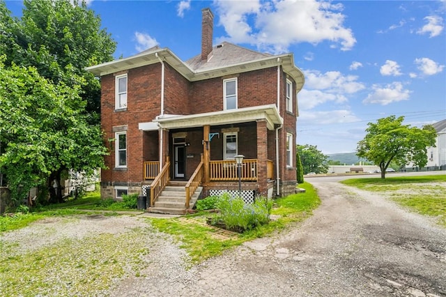 520 Morrell Ave, Connellsville, PA 15425 - view of front of house featuring brick siding, a porch, a chimney, and driveway