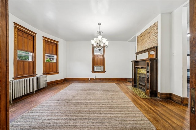 520 Morrell Ave, Connellsville, PA 15425 - unfurnished dining area with radiator, dark wood-type flooring, a chandelier, a tiled fireplace, and cooling unit