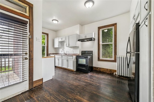 520 Morrell Ave, Connellsville, PA 15425 - kitchen with electric range, radiator heating unit, under cabinet range hood, dark wood finished floors, and white cabinetry