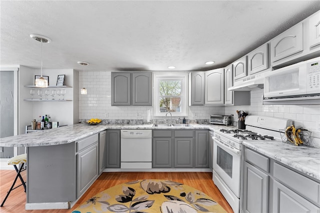 205 Cottage St, Neville Twp, PA 15225 - kitchen with white appliances, gray cabinetry, a peninsula, under cabinet range hood, and light wood-style floors