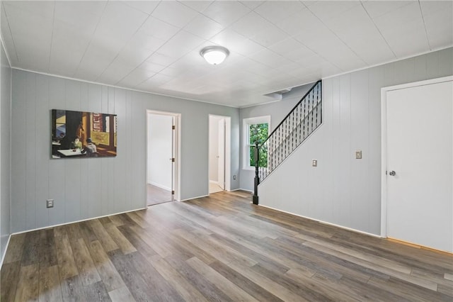 1723 Kimball Ave, Arnold, PA 15068 - unfurnished living room with wood finished floors, stairs, and wood walls