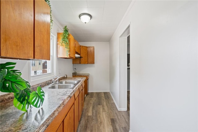 1723 Kimball Ave, Arnold, PA 15068 - kitchen featuring dark wood-style flooring, brown cabinetry, ornamental molding, and under cabinet range hood