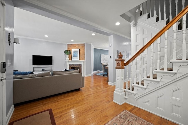 215 Emerson St, Shadyside, PA 15206 - living room featuring light wood-style flooring, crown molding, recessed lighting, stairway, and a large fireplace