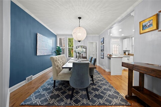 215 Emerson St, Shadyside, PA 15206 - dining area featuring plenty of natural light, a chandelier, light wood-style flooring, and ornamental molding
