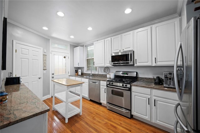 215 Emerson St, Shadyside, PA 15206 - kitchen with appliances with stainless steel finishes, white cabinetry, ornamental molding, light wood finished floors, and recessed lighting