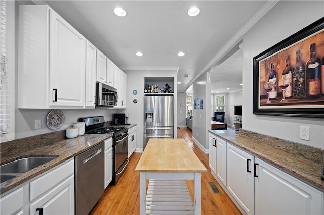 215 Emerson St, Shadyside, PA 15206 - kitchen with appliances with stainless steel finishes, crown molding, white cabinets, light wood-style floors, and light stone counters