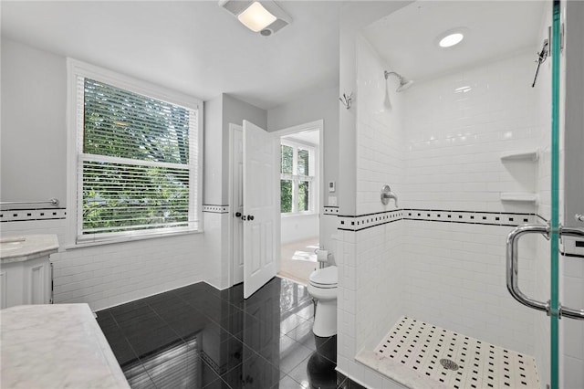 215 Emerson St, Shadyside, PA 15206 - bathroom featuring a shower stall, vanity, wainscoting, and tile walls