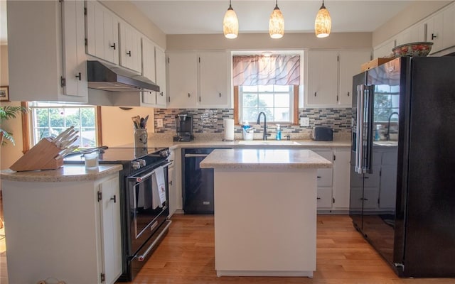 32 Dunham Dr, Hempfield Twp Wml, PA 15601 - kitchen with black appliances, under cabinet range hood, light wood-style floors, backsplash, and a kitchen island