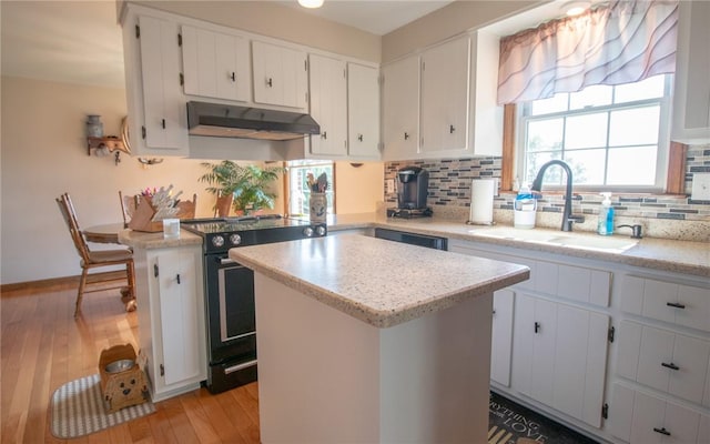 32 Dunham Dr, Hempfield Twp Wml, PA 15601 - kitchen with electric range, under cabinet range hood, light wood-style floors, decorative backsplash, and a center island