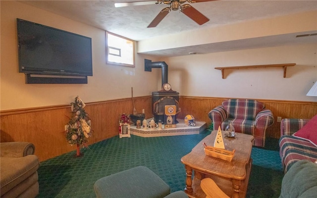 32 Dunham Dr, Hempfield Twp Wml, PA 15601 - carpeted living area with a wood stove, wainscoting, wood walls, and a ceiling fan