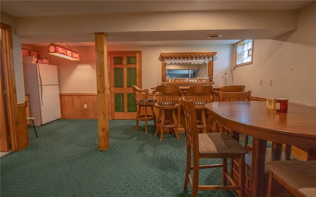 32 Dunham Dr, Hempfield Twp Wml, PA 15601 - carpeted dining space featuring a dry bar, wainscoting, and wooden walls
