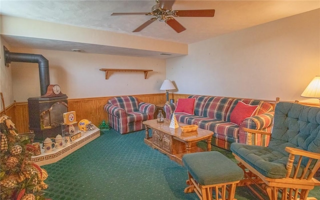 32 Dunham Dr, Hempfield Twp Wml, PA 15601 - carpeted living area featuring wainscoting, a wood stove, a ceiling fan, and wooden walls