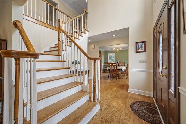 110 Northgate, West Mifflin, PA 15122 - foyer entrance with light wood-style flooring, stairs, a high ceiling, and a chandelier