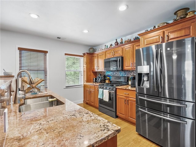 1556 Island Ave, Stowe Twp, PA 15136 - kitchen featuring stainless steel appliances, light wood-style floors, brown cabinetry, and recessed lighting
