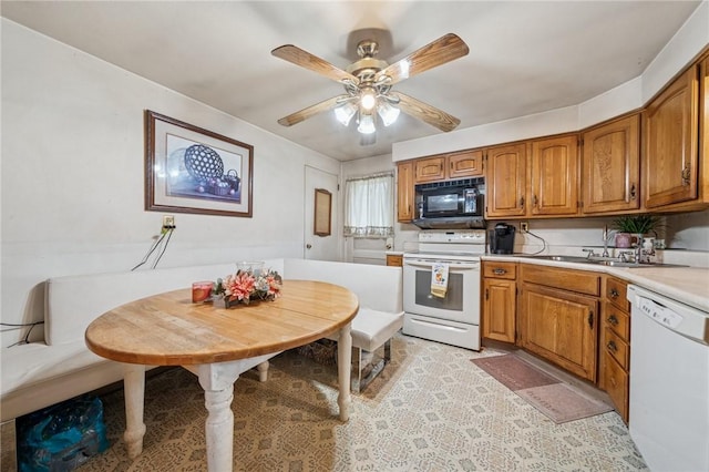 23 Corbett Ave, Hempfield Twp Wml, PA 15642 - kitchen featuring white appliances, brown cabinets, light countertops, and a ceiling fan