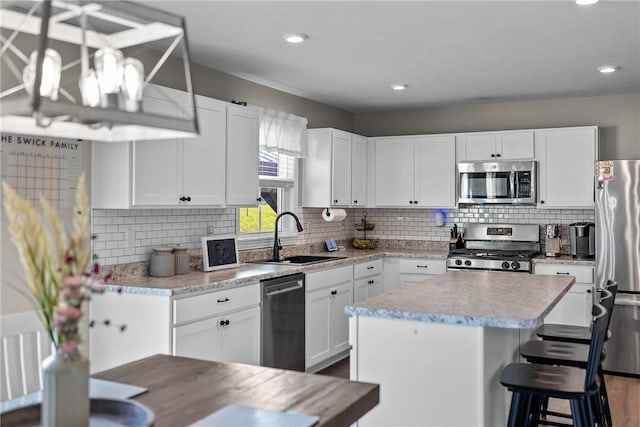 226 Stevens Ct, South Strabane, PA 15301 - kitchen with appliances with stainless steel finishes, a center island, tasteful backsplash, white cabinets, and recessed lighting