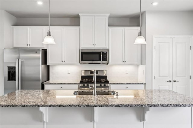 489 Nolan Cir, Cranberry Twp, PA 16066 - kitchen with appliances with stainless steel finishes, white cabinets, decorative light fixtures, stone counters, and an island with sink