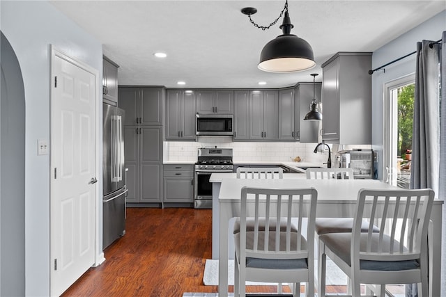 1020 Granite Dr, South Fayette, PA 15057 - kitchen featuring appliances with stainless steel finishes, gray cabinetry, a peninsula, decorative backsplash, and dark wood-style flooring