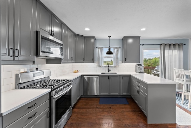 1020 Granite Dr, South Fayette, PA 15057 - kitchen featuring appliances with stainless steel finishes, gray cabinets, a peninsula, tasteful backsplash, and dark wood-style flooring