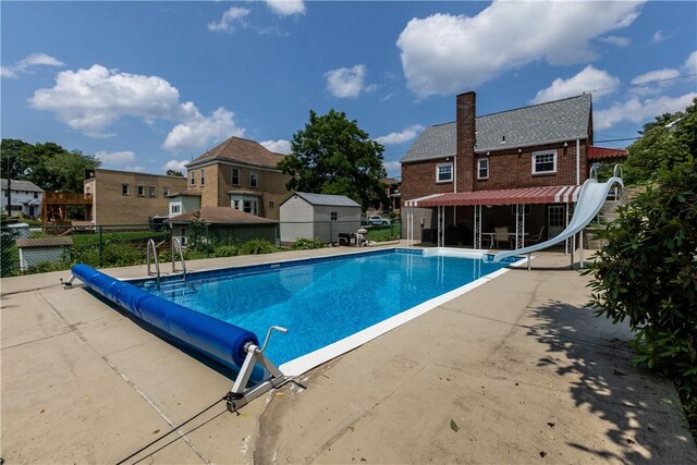 1031 Stratmore St, Ingram, PA 15205 - view of pool featuring a water slide, a patio, a residential view, and a storage shed