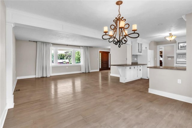 626 Solomon Temple Rd, Unity Twp, PA 15650 - unfurnished living room with a chandelier, wood finished floors, and crown molding