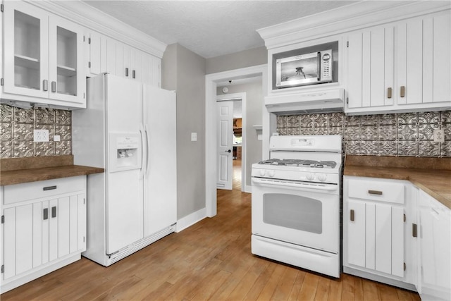 626 Solomon Temple Rd, Unity Twp, PA 15650 - kitchen with white appliances, under cabinet range hood, backsplash, light wood-style floors, and white cabinetry