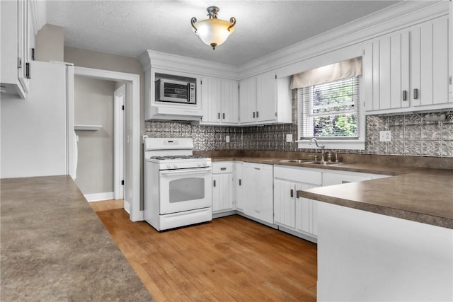 626 Solomon Temple Rd, Unity Twp, PA 15650 - kitchen featuring white appliances, ventilation hood, dark countertops, light wood-style flooring, and white cabinetry