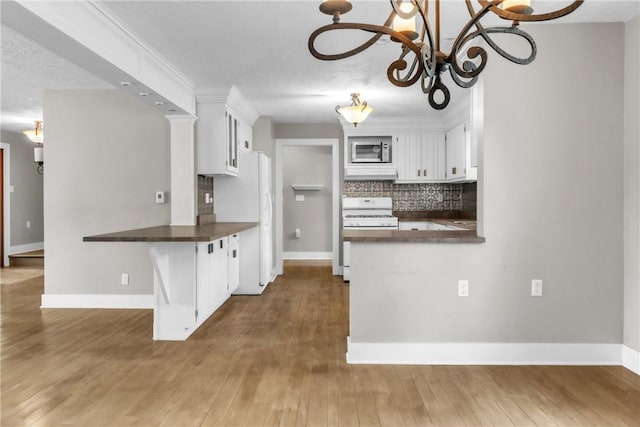 626 Solomon Temple Rd, Unity Twp, PA 15650 - kitchen featuring dark countertops, a chandelier, white appliances, white cabinets, and decorative backsplash