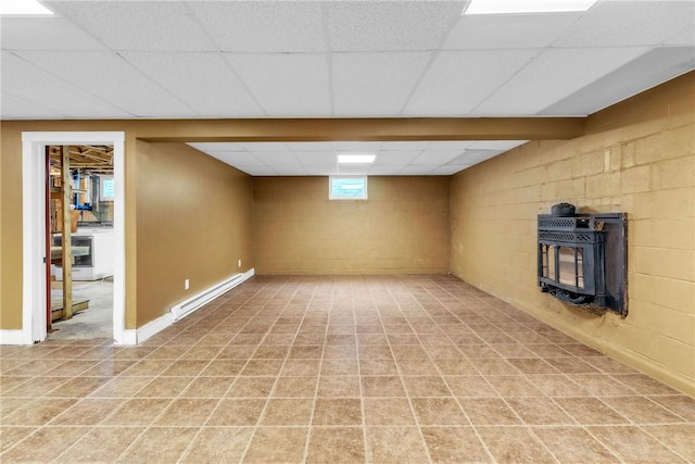 626 Solomon Temple Rd, Unity Twp, PA 15650 - below grade area with a baseboard heating unit, a wood stove, a paneled ceiling, and concrete block wall