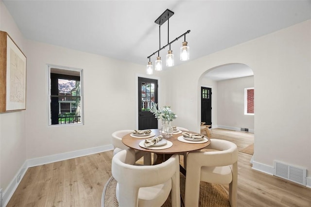 1313 Ingham St, Marshall Shadeland, PA 15212 - dining room featuring arched walkways, light wood-type flooring, and healthy amount of natural light