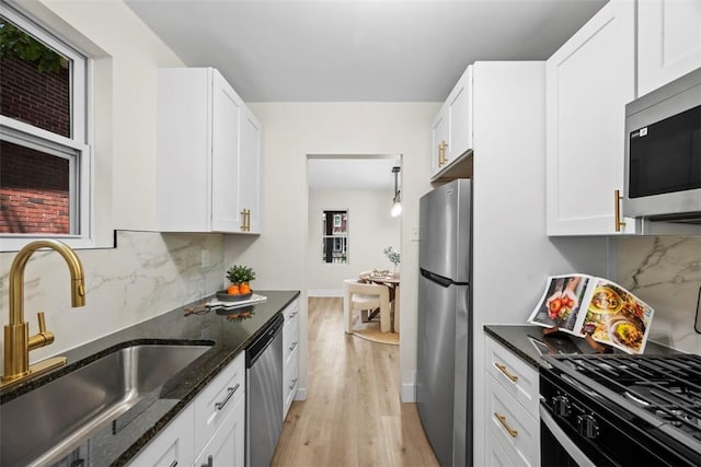 1313 Ingham St, Marshall Shadeland, PA 15212 - kitchen featuring appliances with stainless steel finishes, light wood-style flooring, dark stone countertops, white cabinetry, and backsplash